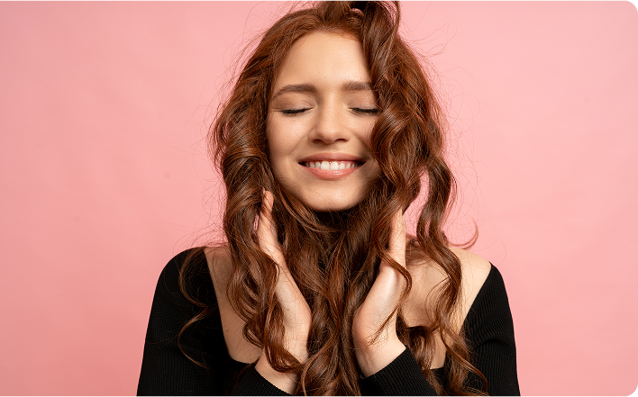 Mulher com as mãos no cabelo sorrindo